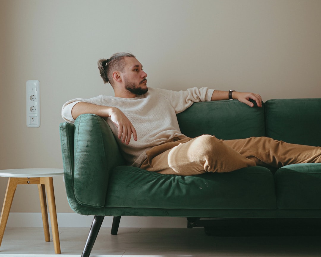 quick recovery vasectomy man resting comfortably on couch with laptop